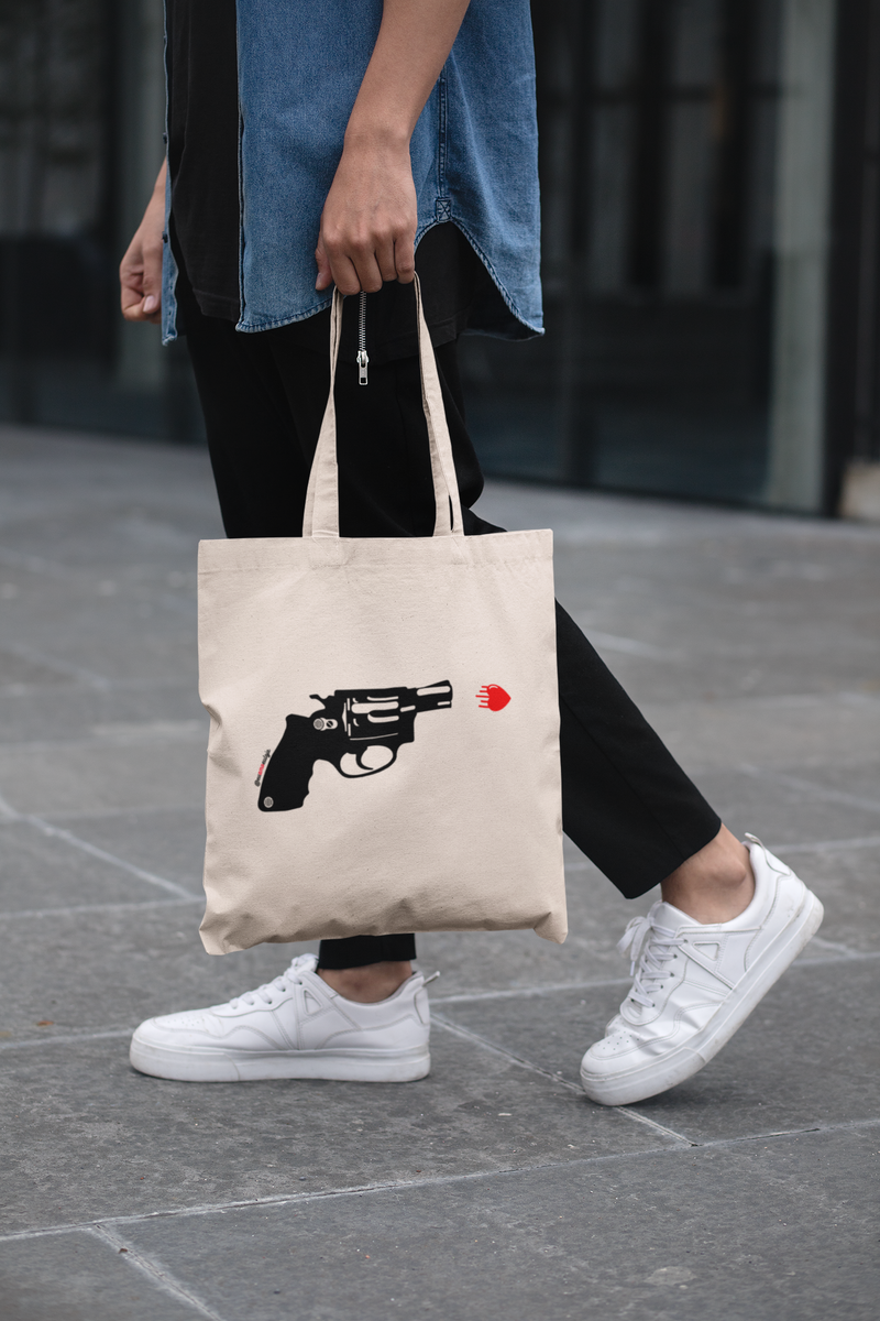 ECOBAG LOVE SHOT - Categoria BOLSAS ECOBAG - Bolsa retornável - Ecológica - Coleções Eu Amo Eu Loja  - @euamoeu.loja - Estampa Exclusiva Eu Amo Eu - Design By Vaz (foto moça andando com ecobag eu amo eu)